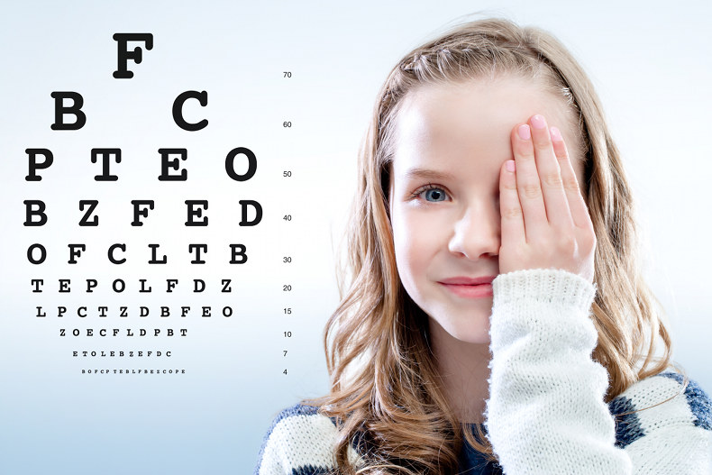 Close up portrait of Girl reviewing eye sight closing eye with hand.Test chart in background.